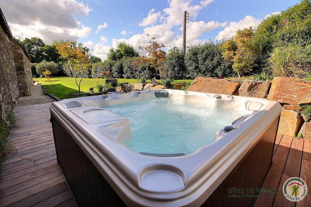 a large hot tub sitting on a deck at La metairie in Plédèliac