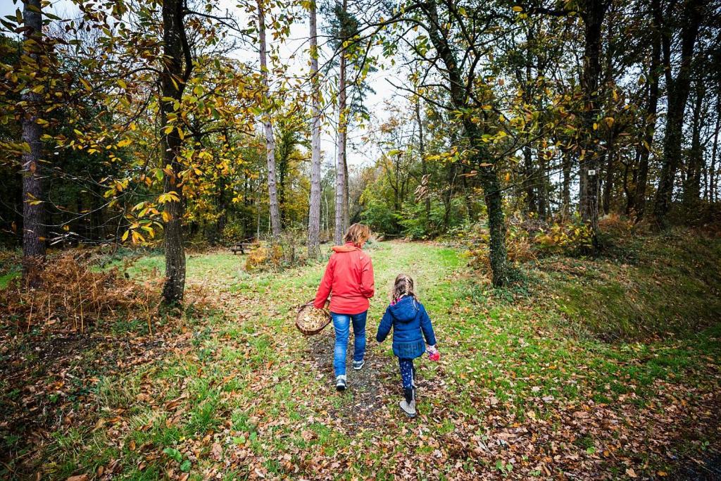a woman and a child walking down a trail at La metairie in Plédèliac