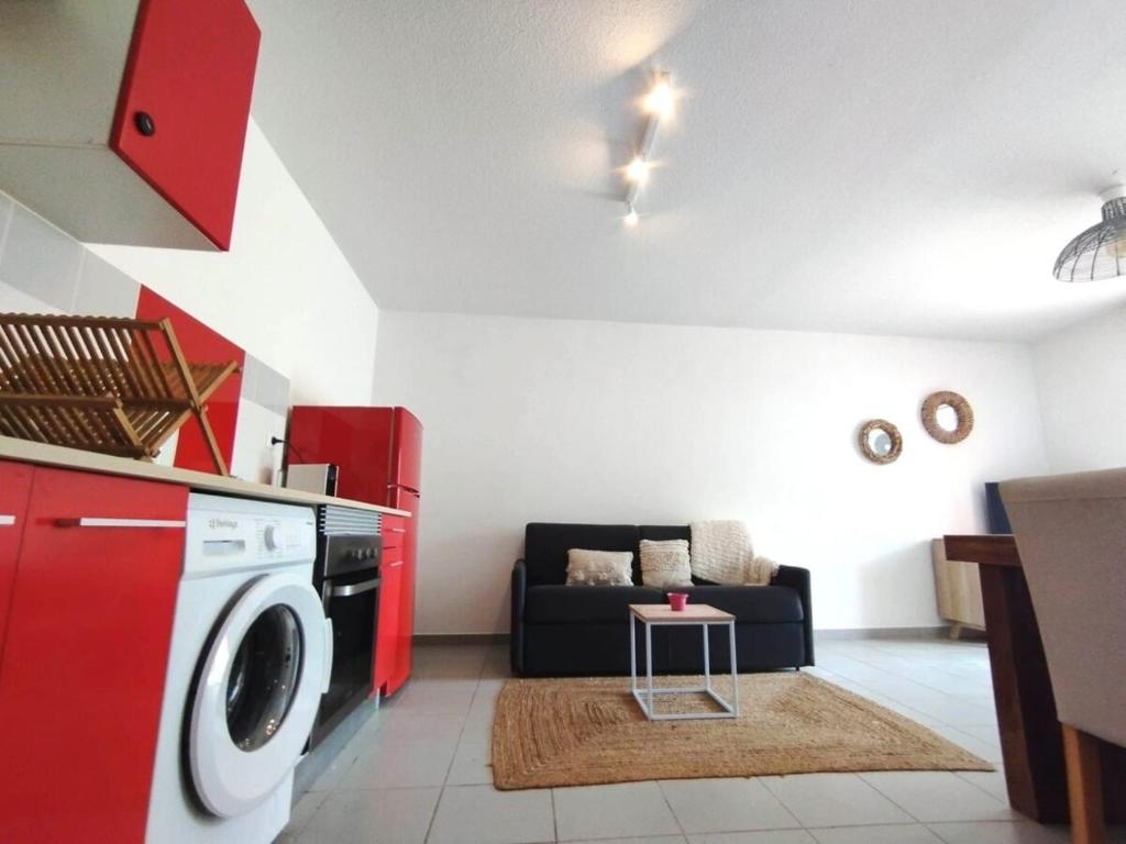 a living room with a washing machine and a couch at Kampagn Jacuzzi - Rémire Wifi et climatisation in Bourda