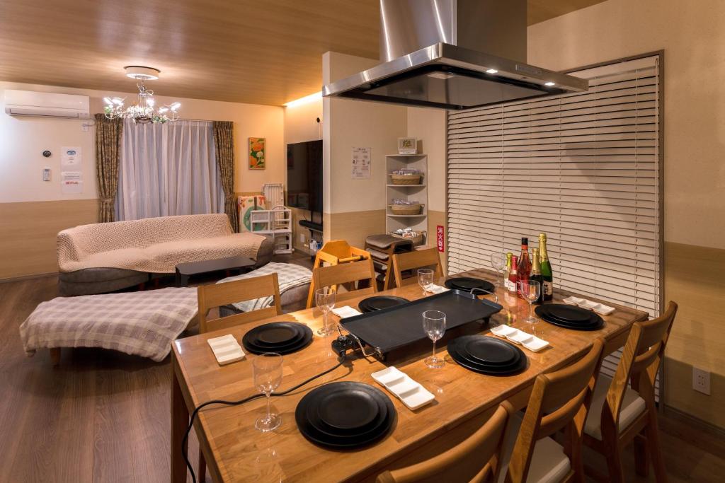 a dining room with a table and a living room at Somnus豊田 ペットOK 最大宿泊人数12名!1棟貸切の宿 in Toyota