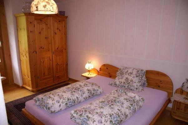 a bedroom with two beds and a dresser with a lamp at Haus 116A in Tarasp