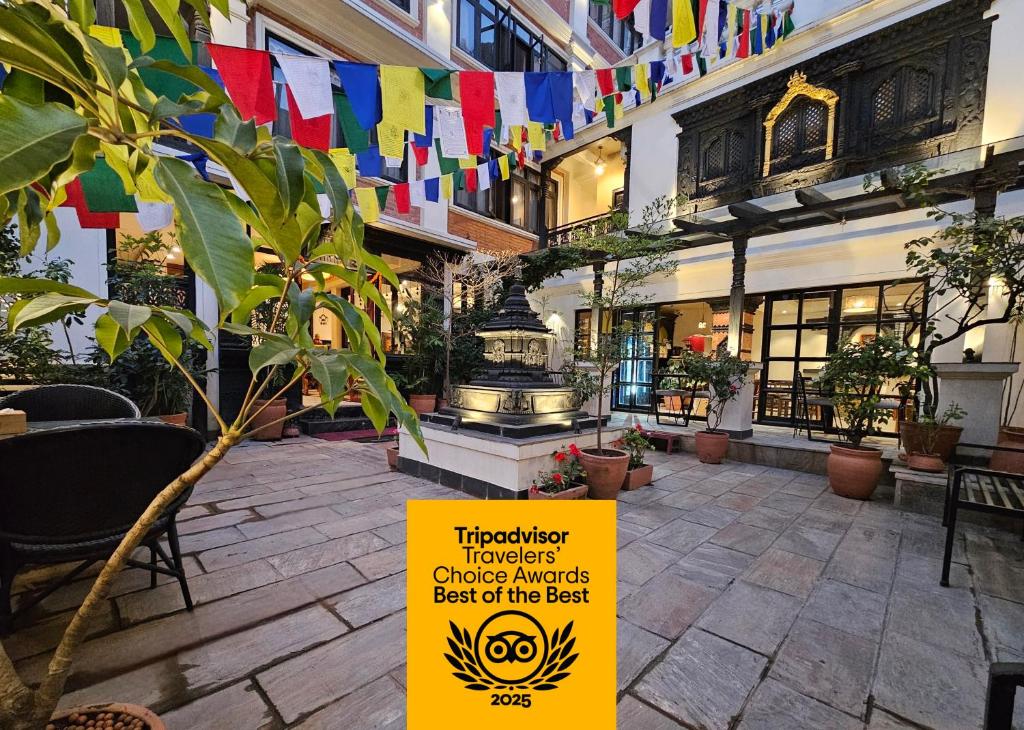 a sign in the courtyard of a building with flags at Central Courtyard Thamel - Kathmandu's Best Kept Secret in Kathmandu