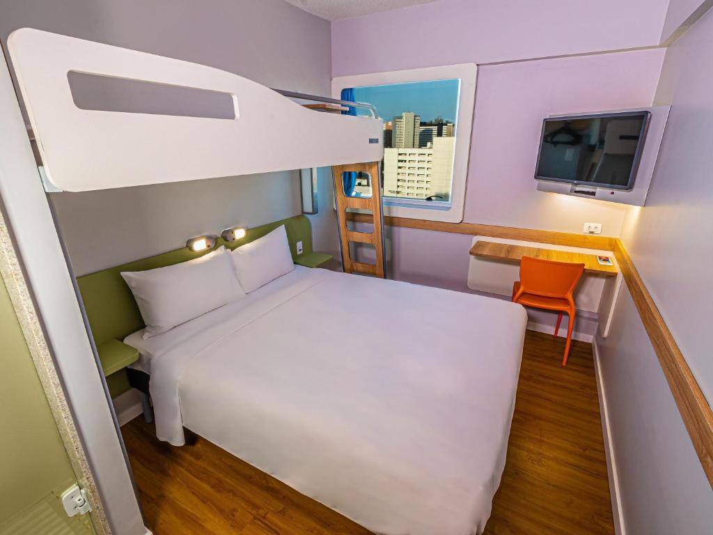 フォルタレザにあるIbis Budget Fortaleza Praia de Iracemaのベッドとテレビのある小さな部屋