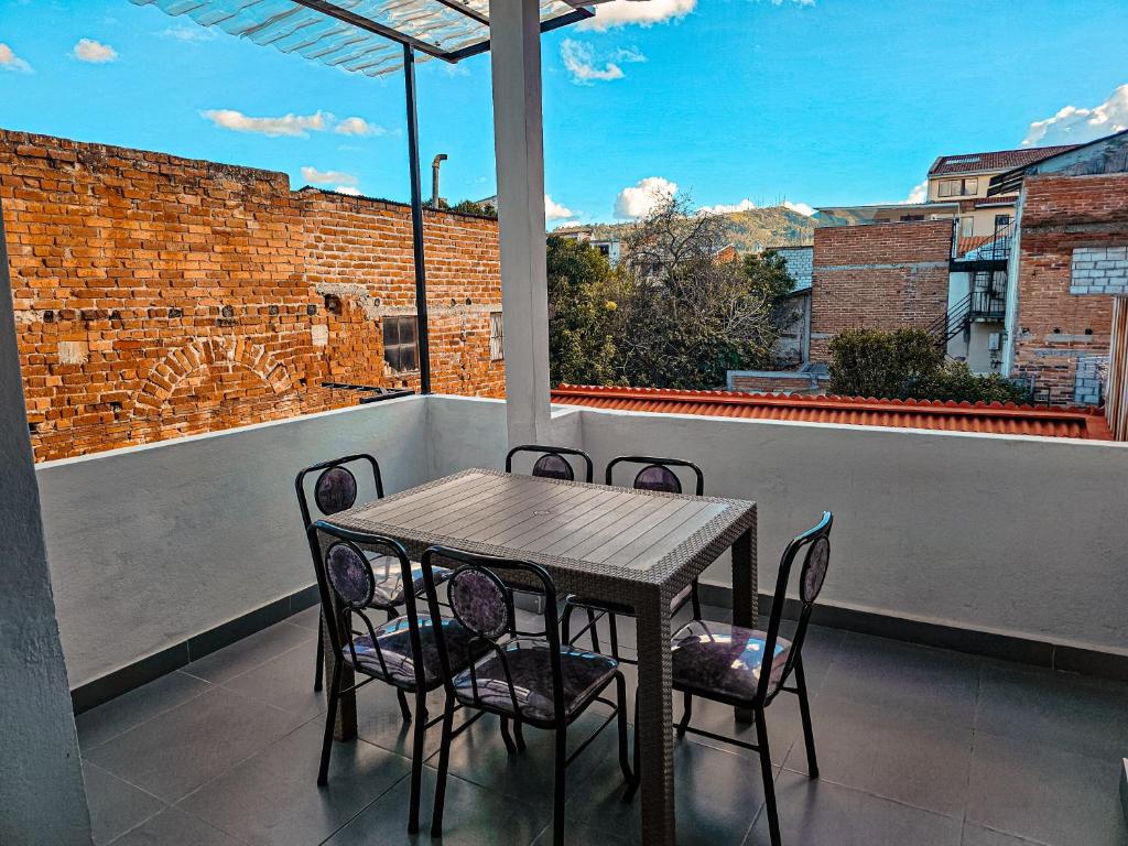Una mesa y sillas en un balcón con ventana. en Departamento en Centro Histórico, en Cuenca