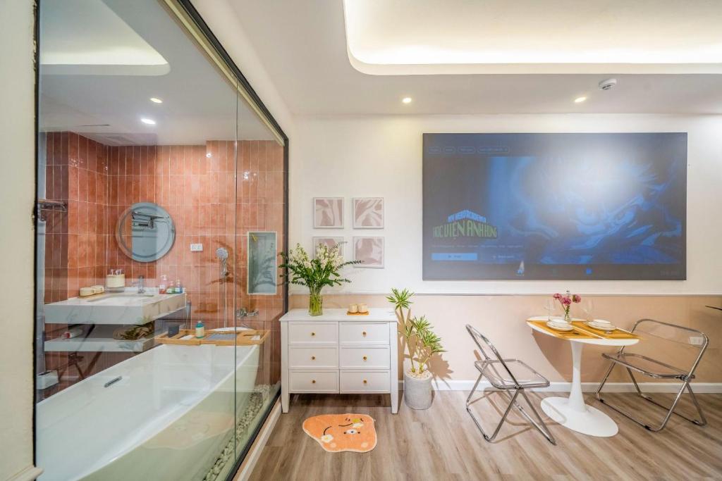 een badkamer met een bad, een wastafel en een tafel bij Aimee House Vũ Miên in Hanoi