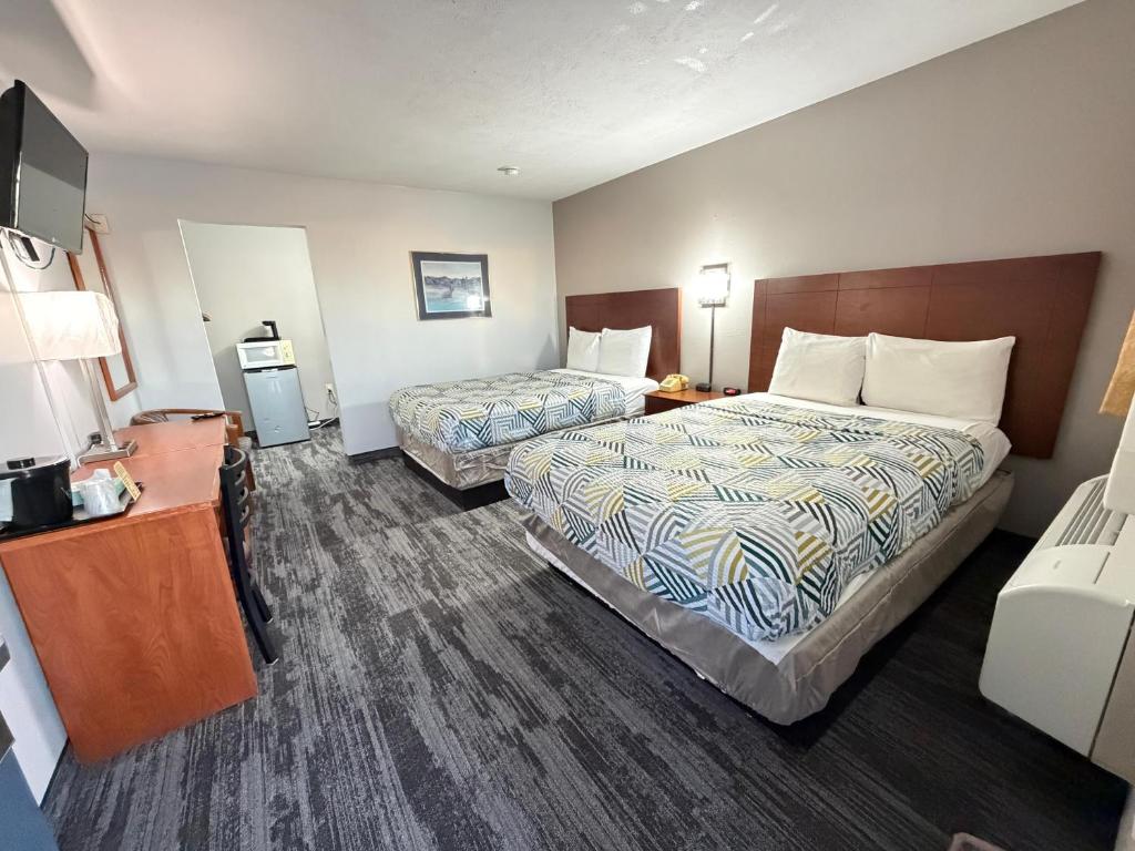 a hotel room with two beds and a television at Regency Inn in Dodge City