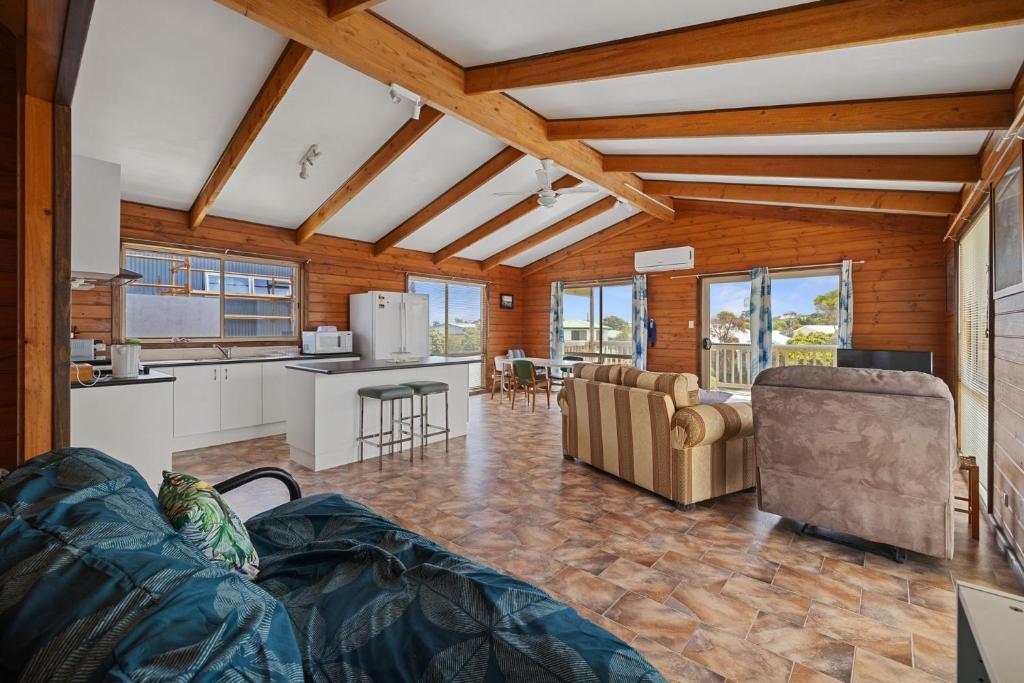 a kitchen and living room with couches and a table at Neptune's Nook in Cape Paterson