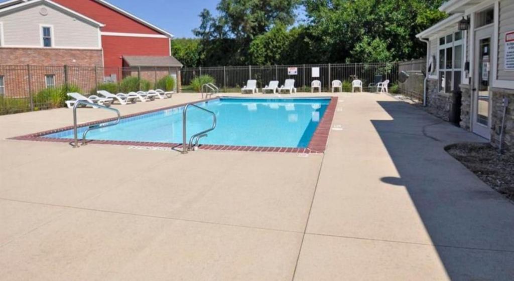 a swimming pool in a yard with chairs around it at Game Day Getaway 5 Min from Notre Dame in Mishawaka