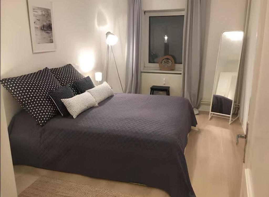 Un dormitorio con una cama con almohadas y una ventana. en Ferienwohnung Horsti, en Timmendorfer Strand