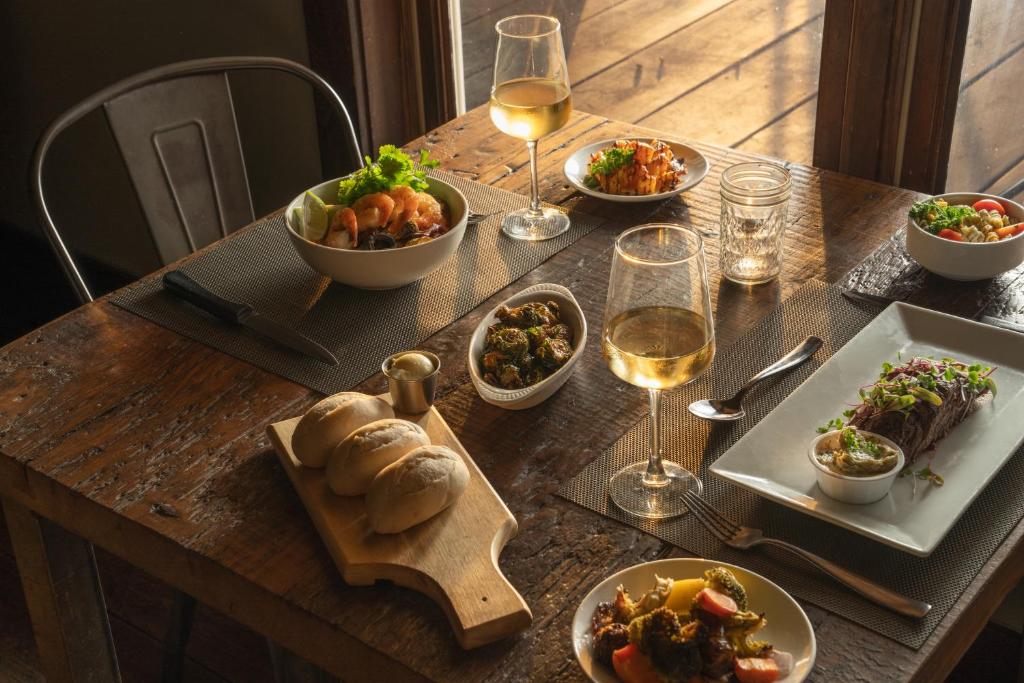 een tafel met borden met eten en glazen wijn bij Sage Hill Inn & Spa in Kyle