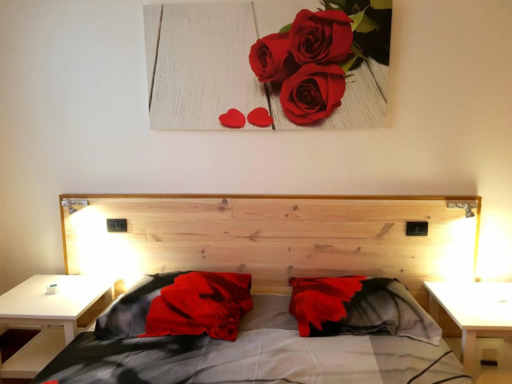 1 dormitorio con 1 cama con 2 rosas rojas en la pared en Al Lago dei Cigni, en Basiglio