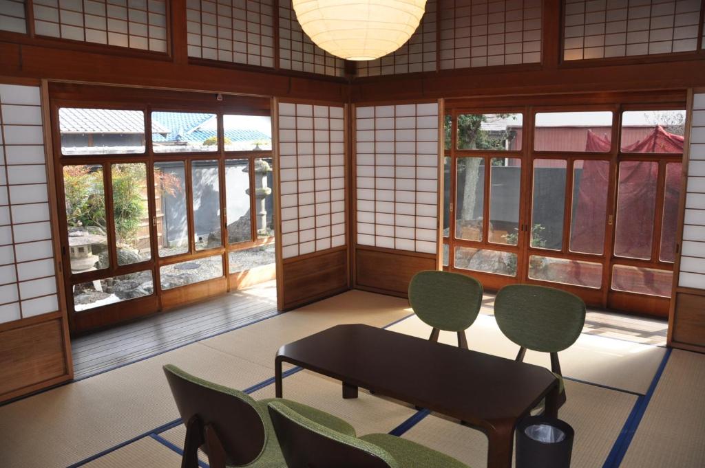 Yuasaにあるいさりの椅子とテーブル、窓が備わる客室です。