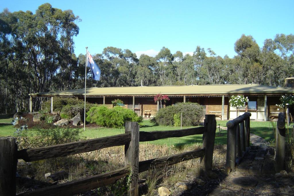 a fence in front of a building with a flag at Gunyah Valley Retreat in Goornong