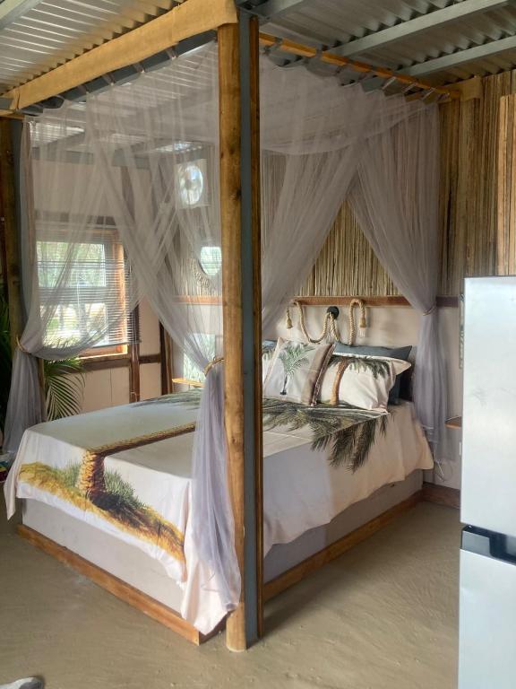 a bedroom with a canopy bed with mosquito nets at Emelios Lodge Océan View in Port Mathurin