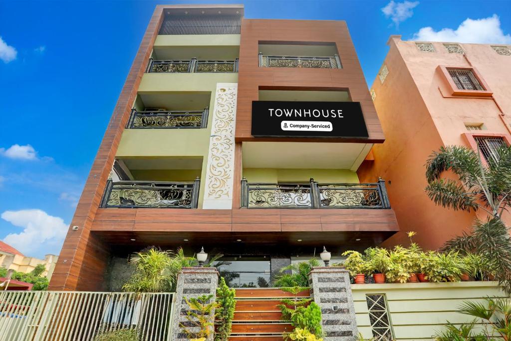 a tall apartment building with a sign that reads townhouse at Super Townhouse Lighthouse Beach Formerly Neel Sagar in Puri
