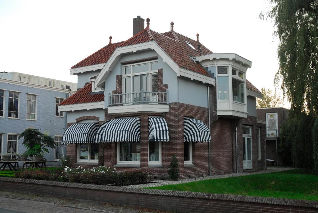 a brick house with an awning on it at Villa Rose in Bergum