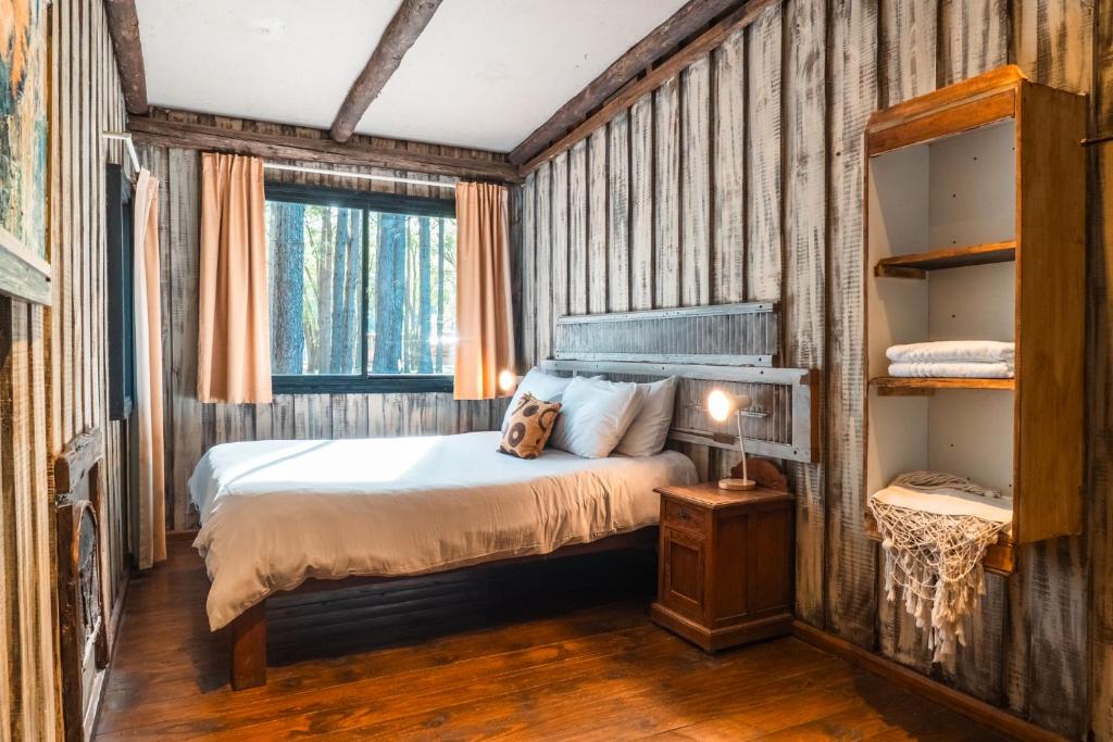a bedroom with a bed with a dog sitting on it at Cabañas en el Bosque a 5 minutos del mar - Estancia CH in Punta del Este