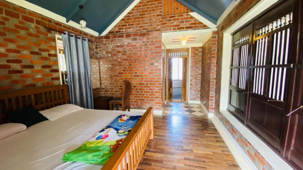 a bedroom with a bed and a brick wall at Nirvikalpa vagamon in Vagamon