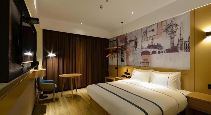 a hotel room with a large bed and a television at City Comfort Inn Shiyan Wudang Mountain in Danjiangkou