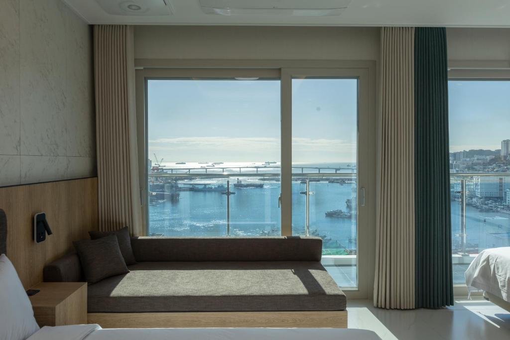 a bedroom with a large window with a view of a harbor at New CZ Nampo Hotel in Busan