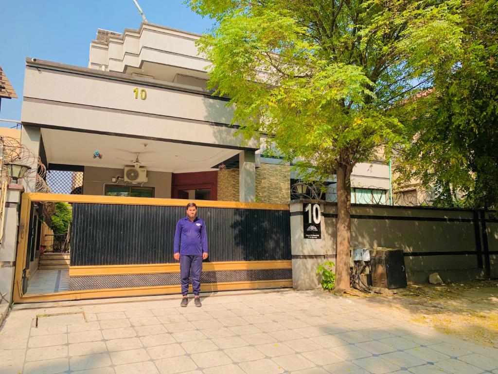 a woman standing in front of a house at Hayat Grand Guest House in Islamabad