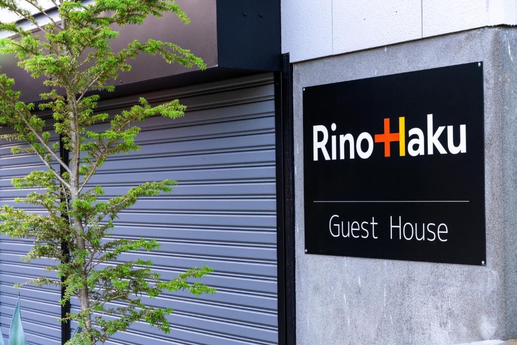 a sign for a guest house next to a garage at Rino-Haku 02 in Anan