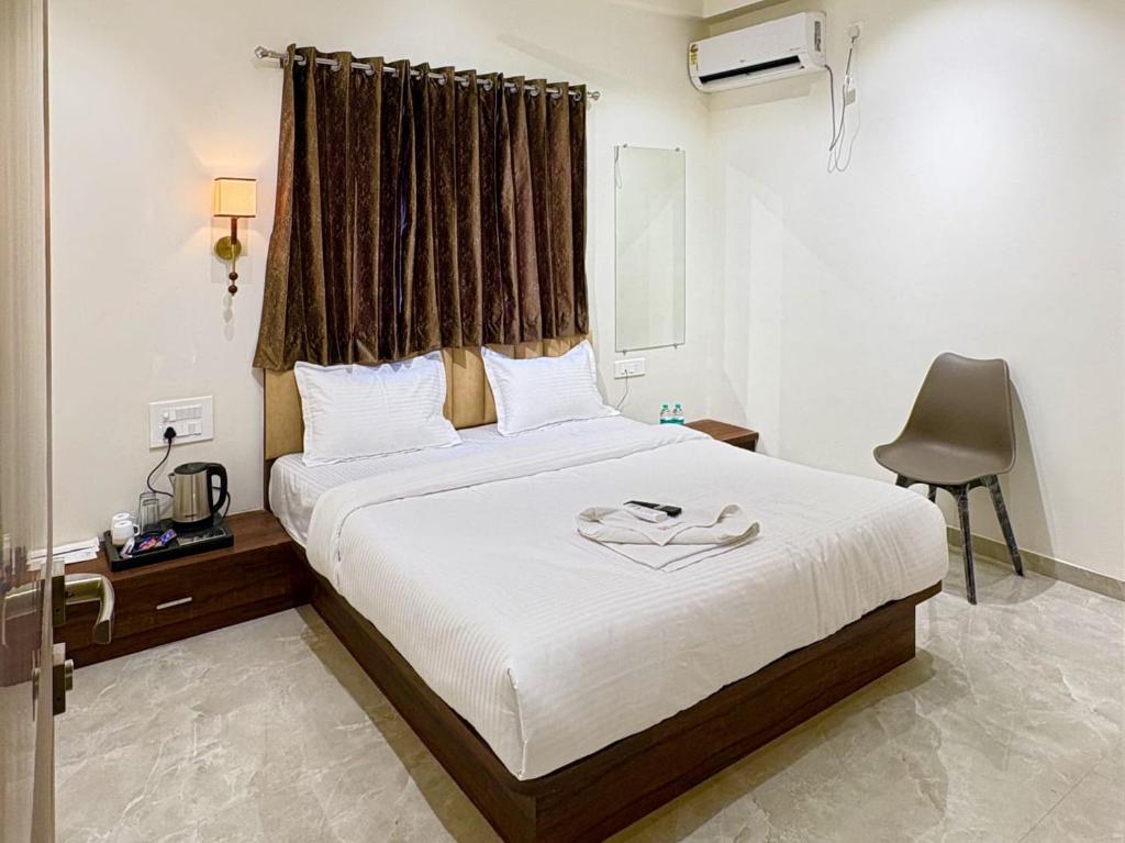 a bedroom with a bed and a desk and a chair at Hotel Riva Inn in Miraj