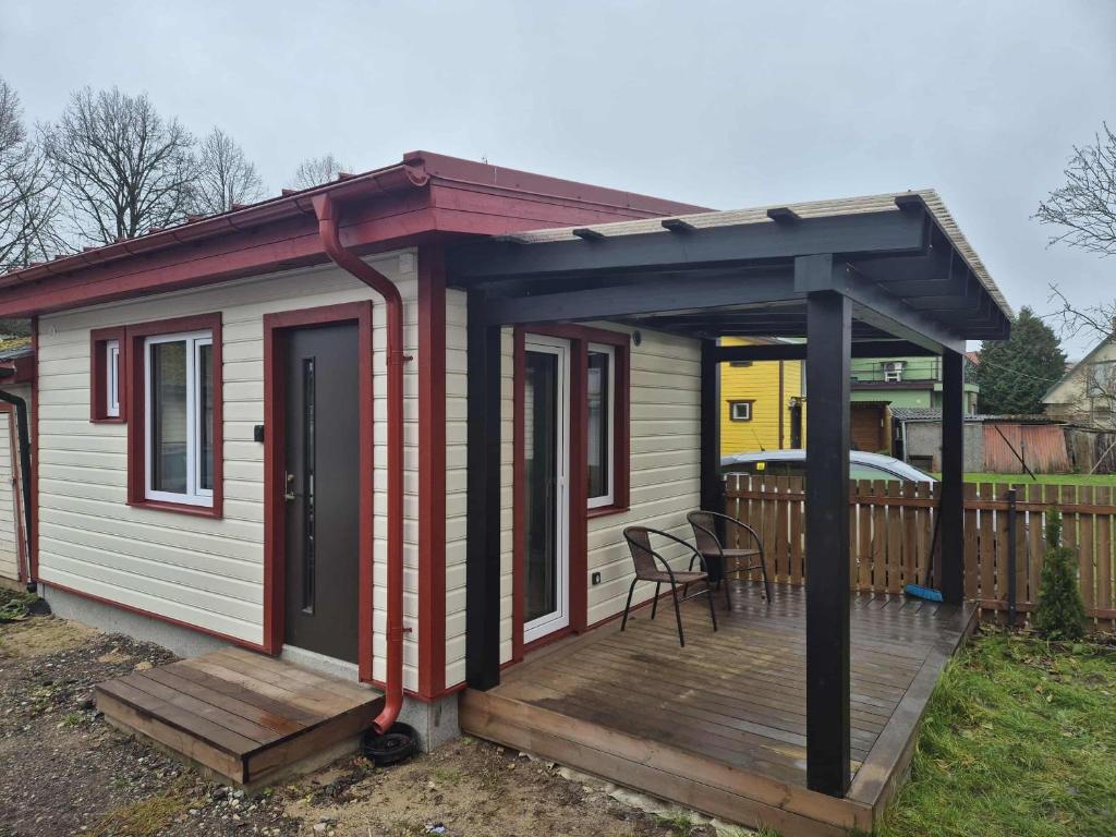 a small house with a deck with a table at Pärnu Summer Studio in Pärnu