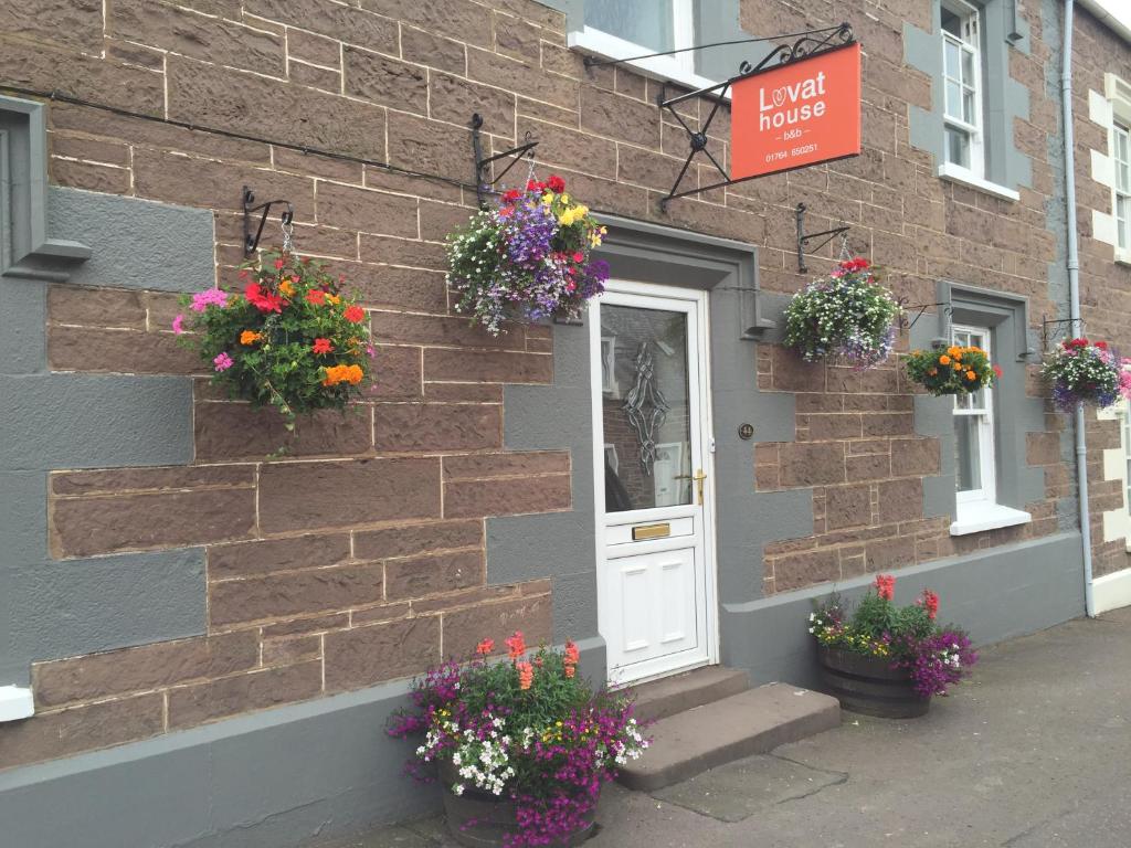 a brick building with flower pots on the side of it at Lovat House in Crieff