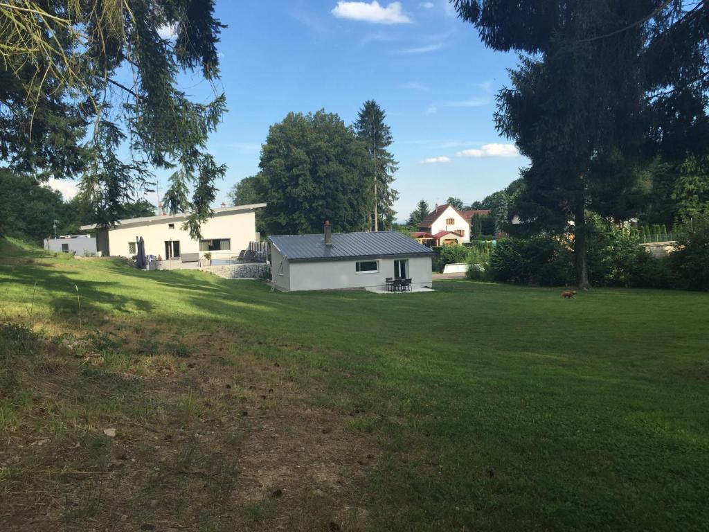 une maison blanche dans un champ avec une cour dans l'établissement Le Clos du Silberthal, à Steinbach