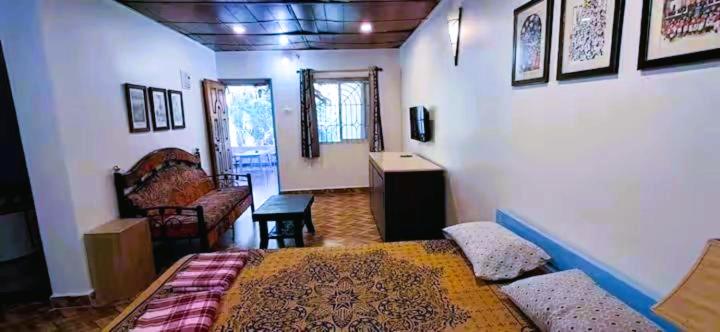 a bedroom with a bed and a couch in a room at Private Spacious family 1 Bhk Apartment in Arambol in Jāmb