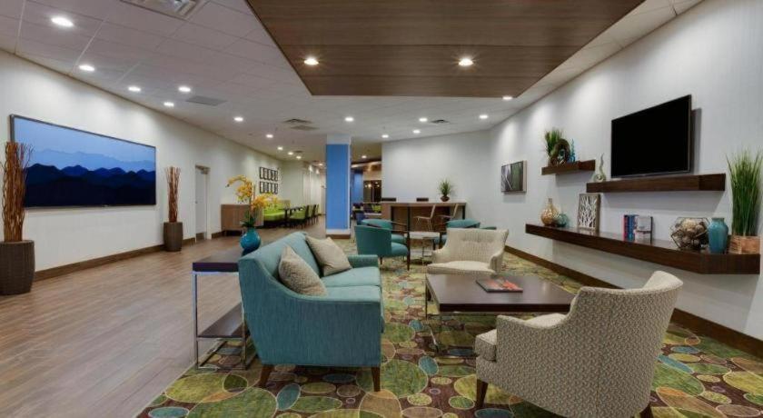 a lobby with a couch and chairs and a tv at Holiday Inn Express Wilkesboro By IHG in Wilkesboro
