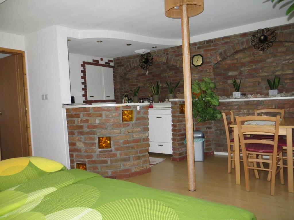 a kitchen and a living room with a brick wall at Studio Lipa in Maribor