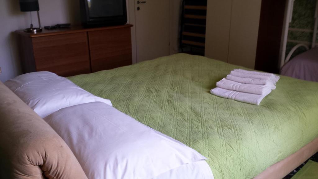 a bed with three folded towels on top of it at B&b La Fattoria in Pastrengo