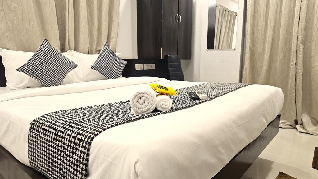 a bedroom with a bed with towels on it at Basil Inn in Pune