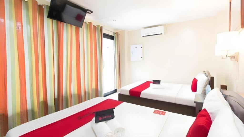 a hotel room with two beds and a flat screen tv at Dino Residences in Daro