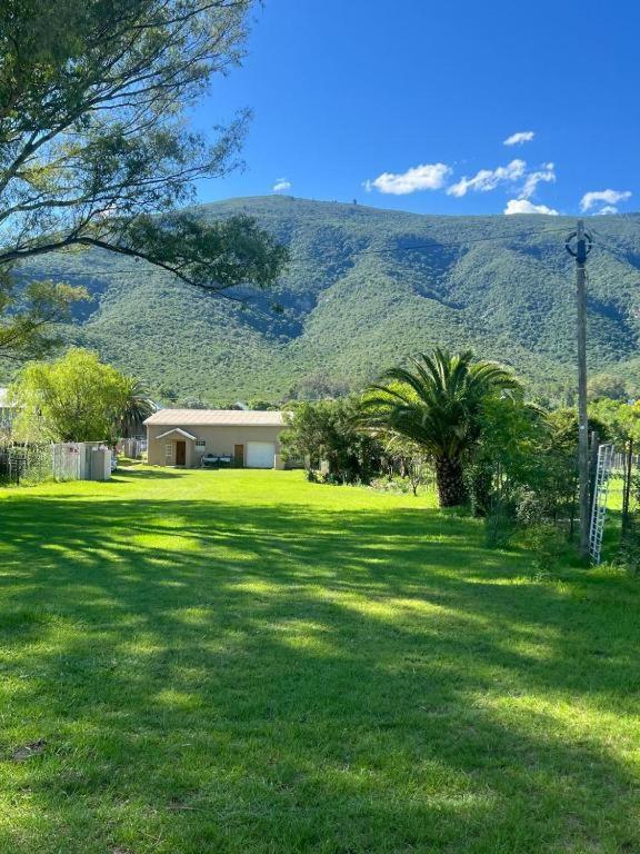 a green yard with a house and a mountain at Boschberg Accommodation in Somerset East