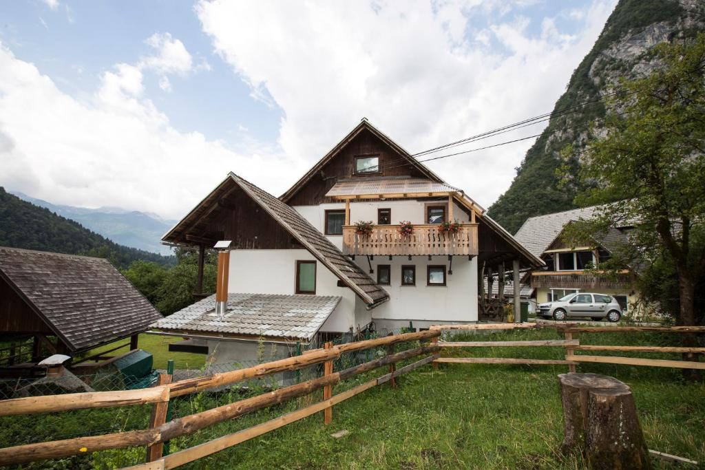 ein Haus in den Bergen mit einem Zaun in der Unterkunft Turistična Kmetija Gartner 3a in Bohinj