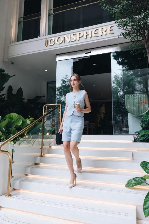 a woman walking down the stairs of a building at IconSphere Hotel in Ho Chi Minh City