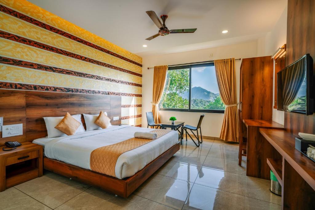 una habitación de hotel con una cama y un televisor en Hotel Woodlark, en Kattappana