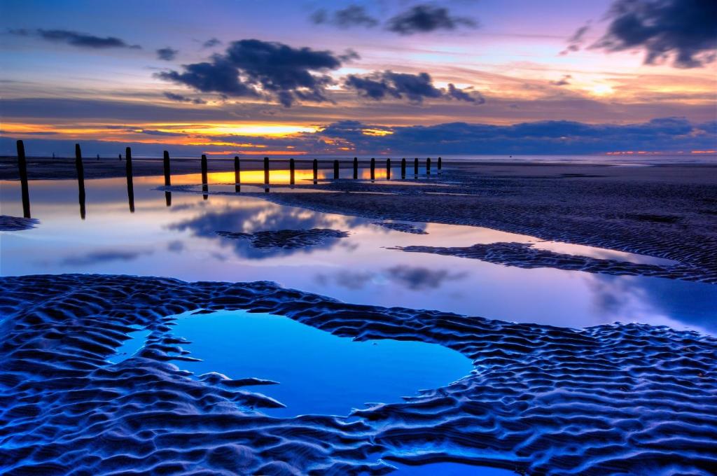 a reflection of a pier on the beach at sunset at Las Palmas Hotel by the Sea in Blackpool
