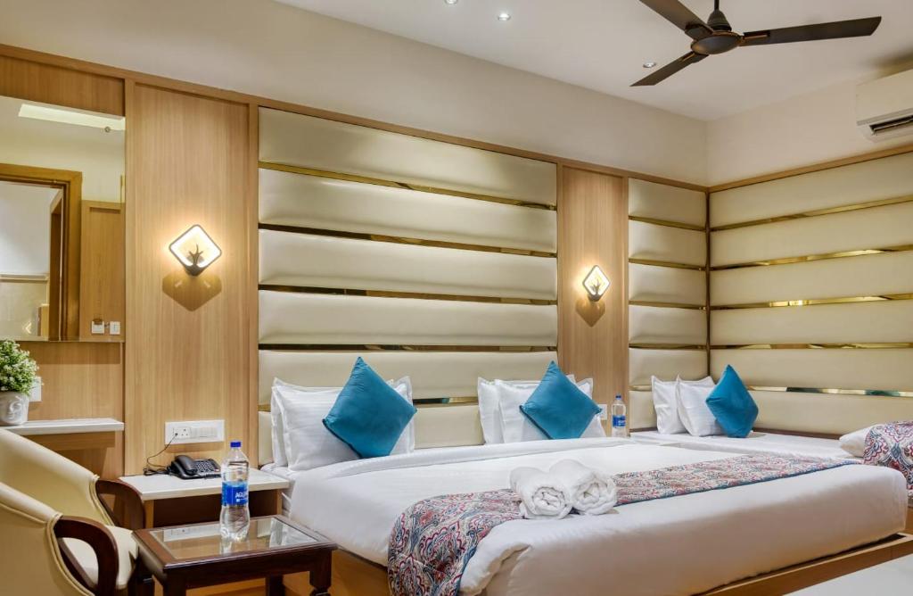 a bedroom with a large bed with blue pillows at Hotel Holiday Dreamz in Amritsar