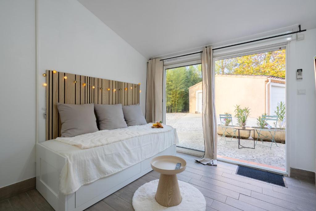 a bedroom with a large bed and a large window at Aréva - Provençal - Climatisé - Parking in Ventabren
