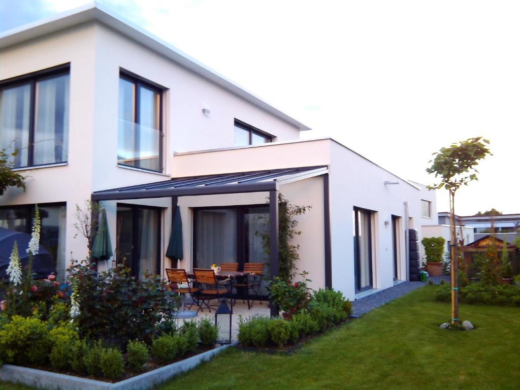 a white house with black windows and a yard at Apartment Bei Linda in Beromünster