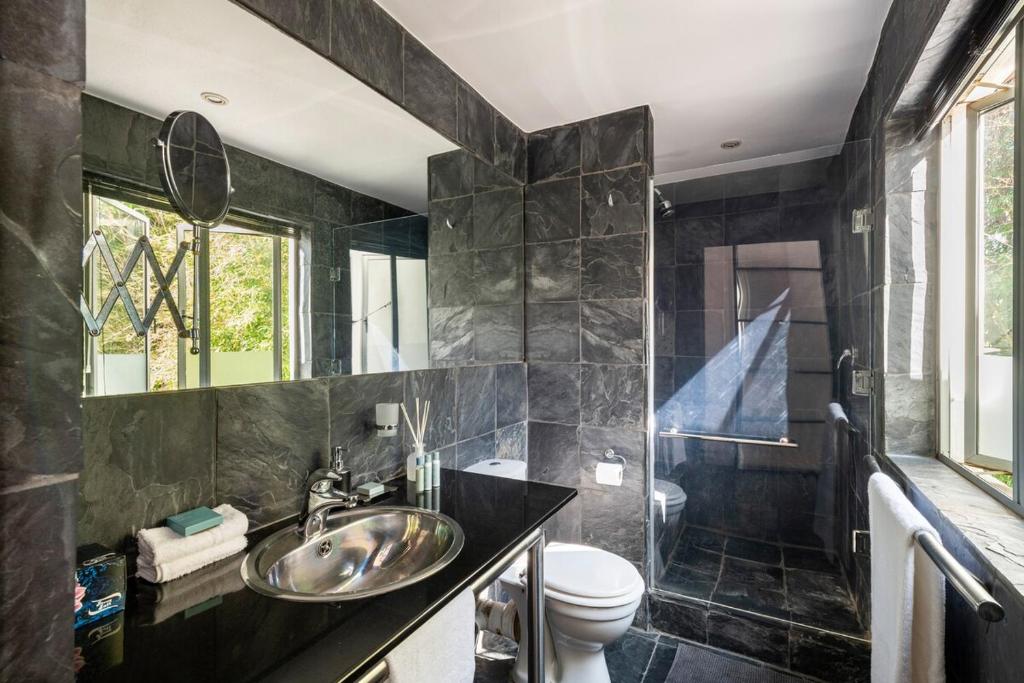 un baño con lavabo e inodoro en Modern studio apartment with solar, en Honeydew