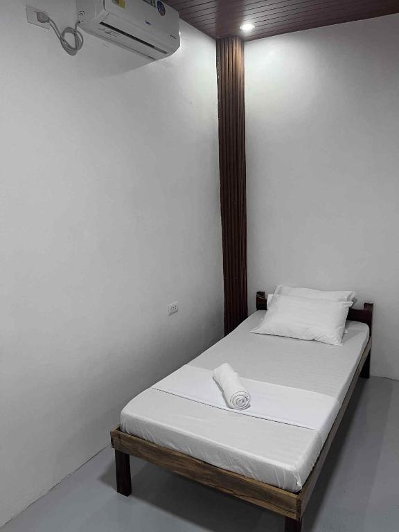 a bed in a room with a white wall at Bergon Homestay in Burgos