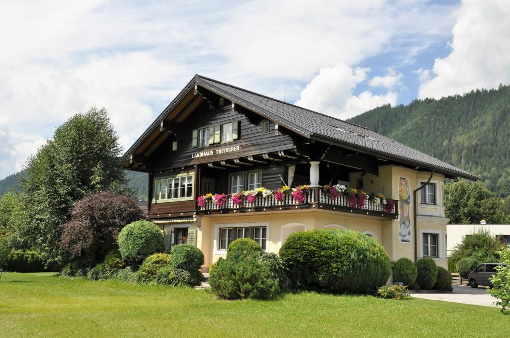 une maison avec un balcon fleuri dans l'établissement Landhaus Tritscher, à Schladming