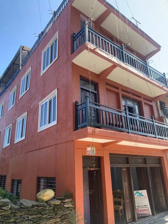 a red building with a balcony on top of it at DIPSAGAR Hotel And Lodge in Bandīpur