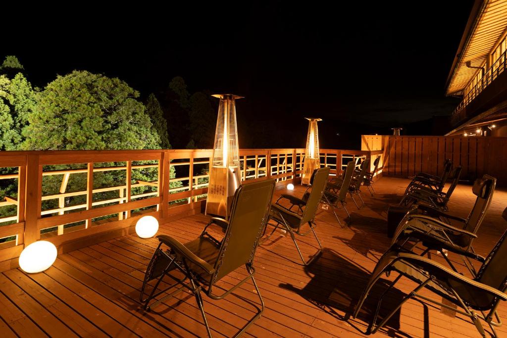 a deck with chairs and lights at night at Ooedo Onsen Monogatari Premium Yoshinoya Irokuen in Kaga