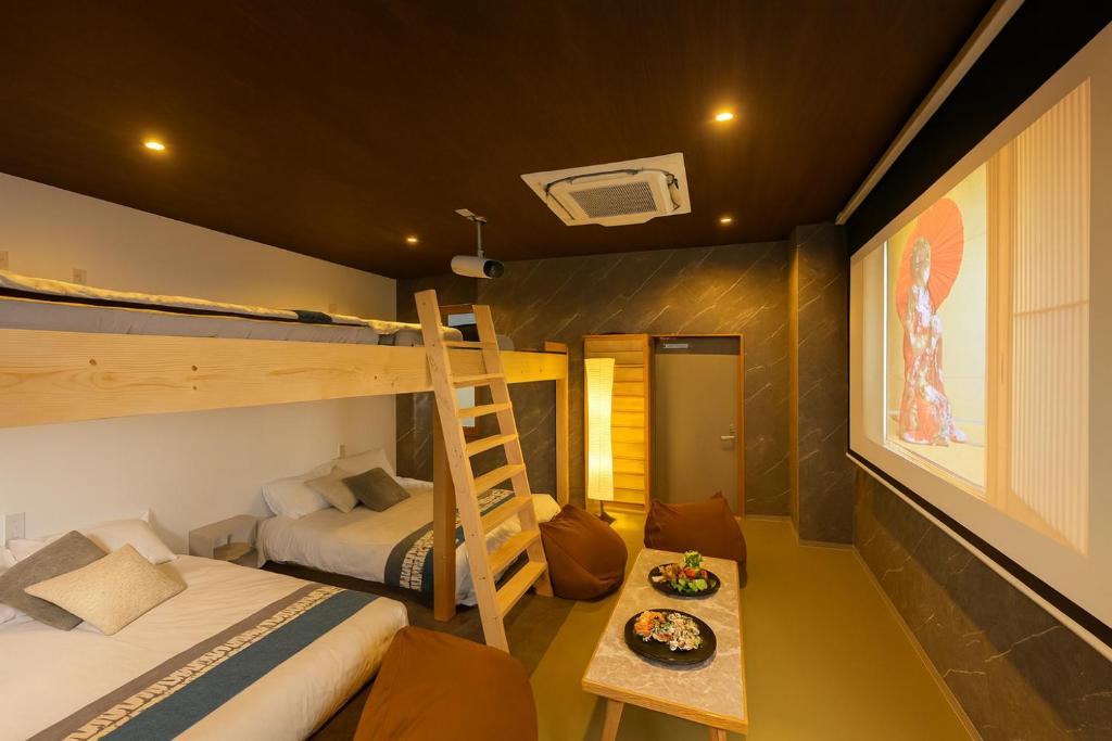 een slaapkamer met twee stapelbedden en een tafel bij 今宵の宿 中州庵 in Fukuoka